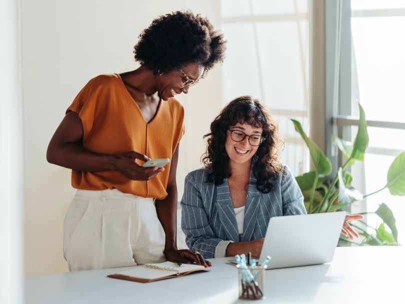 Two colleagues discuss ideas for a project while working together in an office